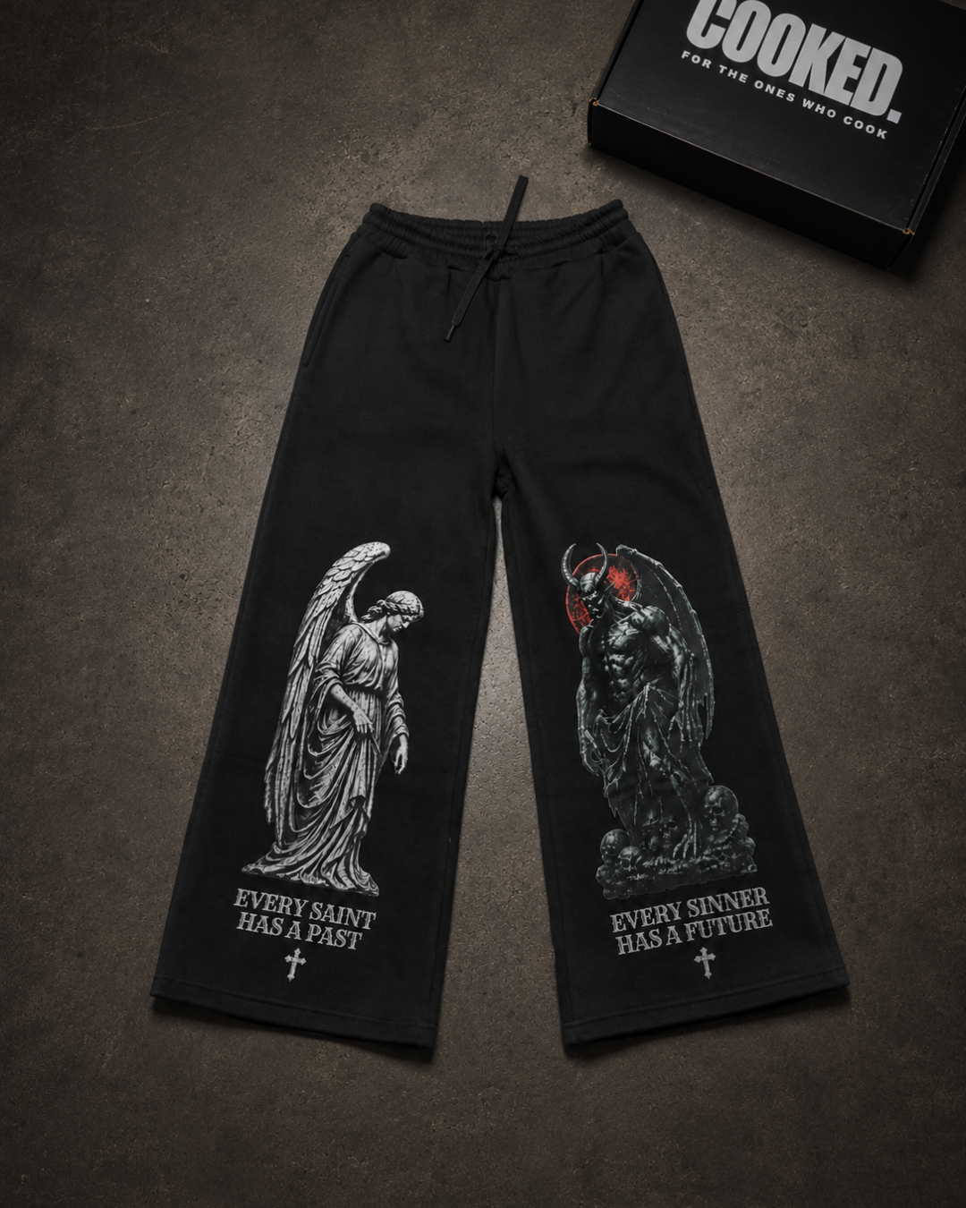 Saint & Sinner wide-leg trackpants flat lay with Cooked box